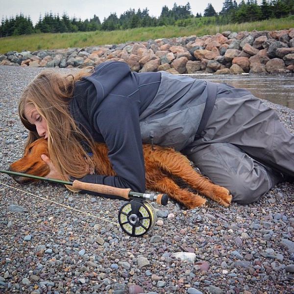 Fishing dog hug on riverbed