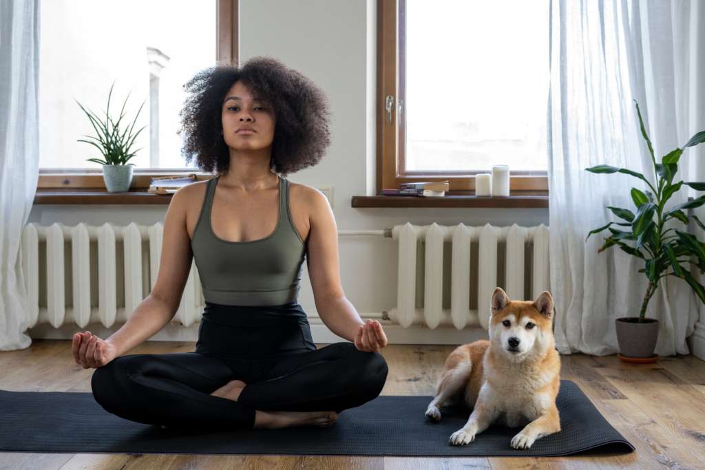 woman doing yoga with her dog