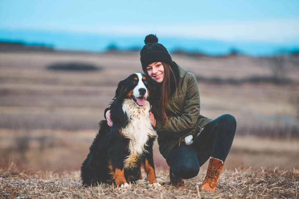 Bernese mountain dog with teenage girl outdoors in the fall